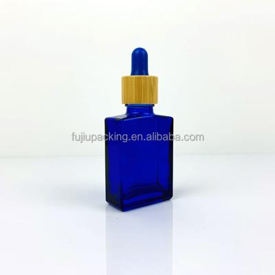 China 30ml Essential Oil Bottle 1oz Blue Rectangle Glass Dropper Bottle With Bamboo Glass Eye Dropper For Perfume for sale