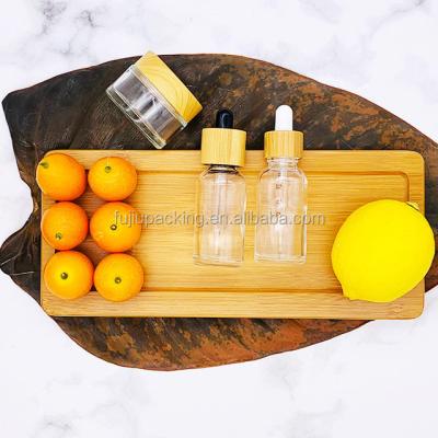 China Round Essential Oil Clear Transparent Glass Dropper Cap Bamboo Bottle For Cosmetic Container With Wooden Screw Lid for sale