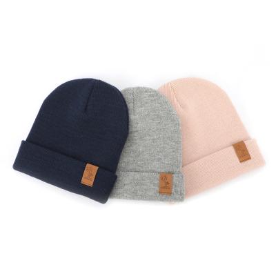 China COMMON Logo Custom Label Skullies Slapped Skullies Ski Hat Winter Warm Acrylic Plain Leather Knitted Hat for sale