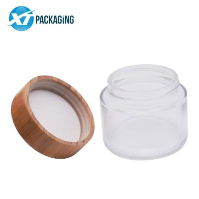 China 2oz stocked viable frosted bamboo flower glass jars lids logo tight engraved logo lid child proof child hat packaging wooden bamboo jar air proof for sale