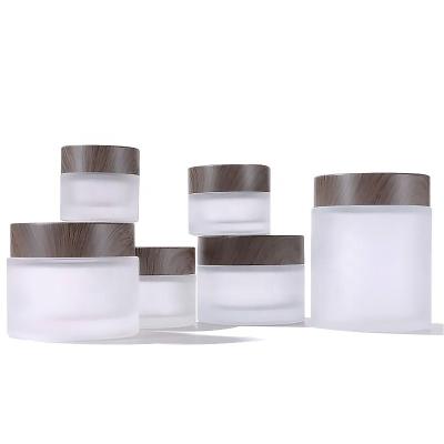 China Free Samples Cosmetic Packaging Skin Care Bottle 5ml 10ml Frosted Glass Round Empty Cream Bottles With Wood Grain Lids for sale