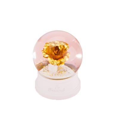 China Decorative Europe Polyresin Snow Globe Glass Ball Gold Rose Snow Globe For Home Decor for sale