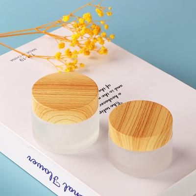 China 5g 10g 15g 20g mini cosmetic empty cosmetic glass packaging with essence wooden lotion lid glass jar for sale