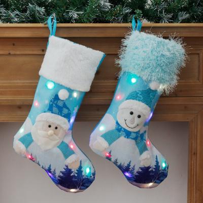 China 2021 New Arrival Blue Canvas Festival Snowman Embroidered LED Light Christmas Stocking Santa Sack Gift Bag With Lights for sale