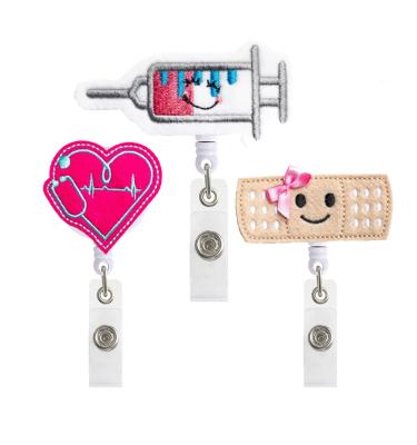 China Custom Felt Retractable Cute Retractable Nurse Badge Holder Nurse Reel Heart Bandage Syringe Badge Holder Name ID Badge Holder QY1102 for sale