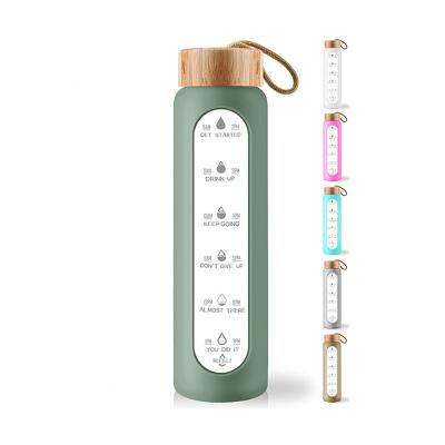 China 1L Amazone Viable Sport Hot Bottle Lid Silicone Sleeve Borosilicate Glass Bamboo Water Bottle with Time Marker and Tea Strainer for sale