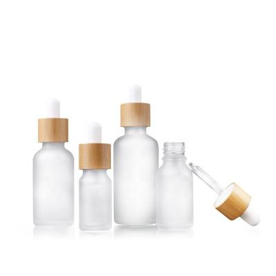 China Custom Luxury Cosmetic Dropper Bottles Frosted Serum Glass Bottles 20ml 30ml 50ml With Natural Bamboo Lid Glass Dropper for sale