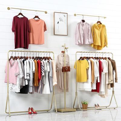 China Shinny Metal Shiny Slatted Gold Metal Wall Mounted Clothing Shops Corner Clothing Rack for sale