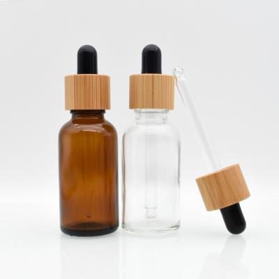 China Custom Hot Sales Environmentally Friendly Amber Clear Black Green Glass With Bamboo Dropper Cap Essential Oil Bottle for sale