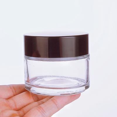 China 100ml Face Cream Cosmetic High Quality Cosmetic Bottle Clear Glass Jar With Plastic Black Lid for sale