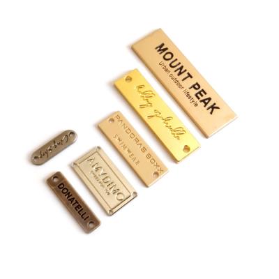 China Eco-friendly Engraved Metal Logo With 2 Holes Sewing Nameplate Gold Plated Metal Label Small Flat Sewing For Garmets for sale