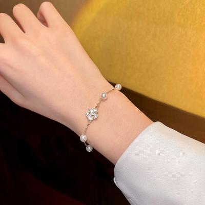 China Trendy Fashion Diamond Bling Bracelet Wholesale Fresh Camellia Flower Pearl Spring Temperament Bracelet Female Retro for sale