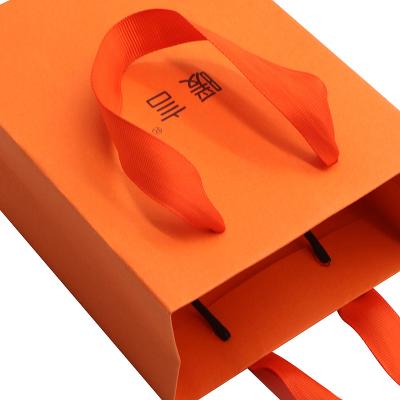 China Disposable Orange Gift Bag With Logo Black Printing Design Gift Paper Bag With Handles Orange Paper Bag for sale