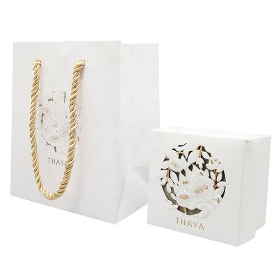 China Handmade Unique Design Customized Pierced White Logo Printing Package Box And Paper Bag Sets for sale