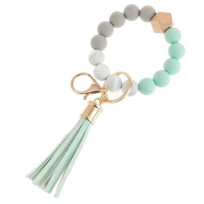 China Fashionable Wooden Elastic Wooden Tassel Bracelet Bangle Bead Silicone Key Chain Bracelet For Women for sale