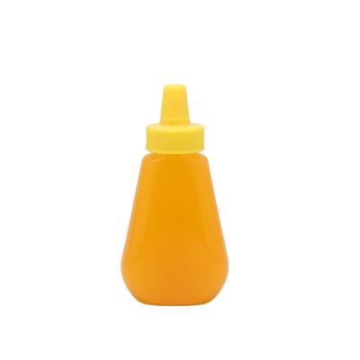 China PET Honey Bottle Sharp Mouth Squeeze Plastic Honey Bottles With Twist Top Cap for sale