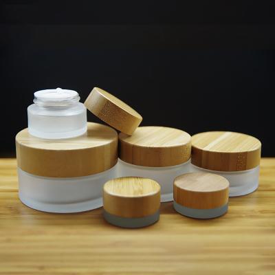 China Eco-friendly 30g 50g high quality refillable bamboo lid cosmetic container for skin care frosted clear empty bamboo glass jar eye cream for sale