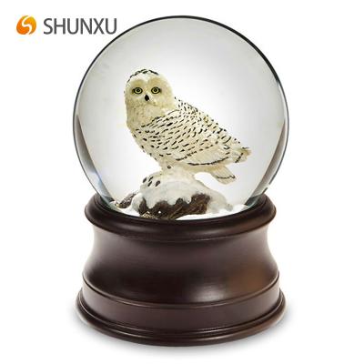 China Simple Classic Resin Snow Globe Europe White Owl Standing On A Snowy Rock Water Globe Desktop Home Decoration for sale