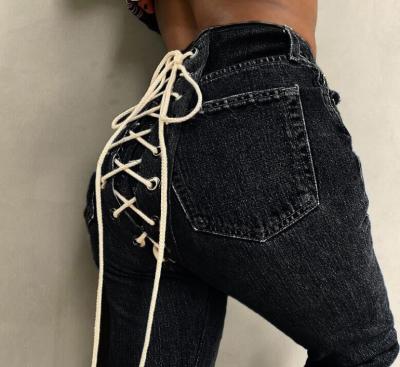 China Strap Fashion Trend Contrast Bandage Eyelet Hollow Out Breathable Tieback Supply Eyelets Jeans Women Ladies Creative Back Pants for sale