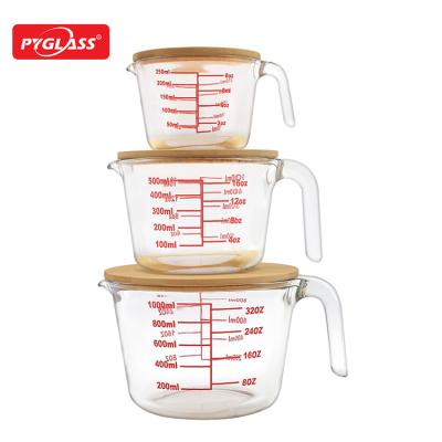 China Microwavable pyrex glass measuring cup with lid bamboo glass measuring jar for sale