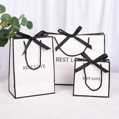 China Recyclable Elegant Small White Bags Bow Horizontal Ribbon Shopping Brand Custom Printing Paper Bag Gift for sale