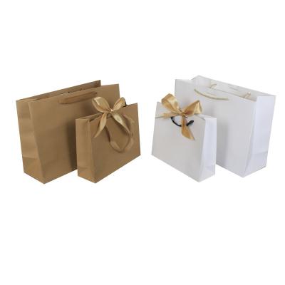 China Recycled Materials Wholesale Exquisite Clothing Packaging Bag Bow Ribbon Gift Bag With Handle for sale