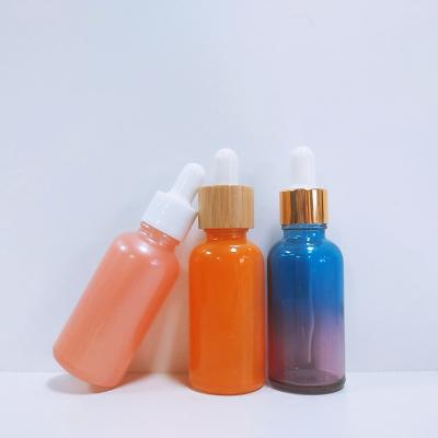 China Screen printing amber cosmetic glass frosted essential oil glass bottles with bamboo dropper and bamboo bottle pump for sale