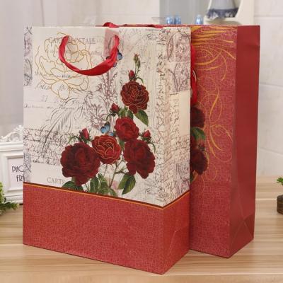 China Recyclable Red Rose Pattern Printing Brown Paper Gift Bags Valentine's Day Chocolate Packaging Paper Bag for sale