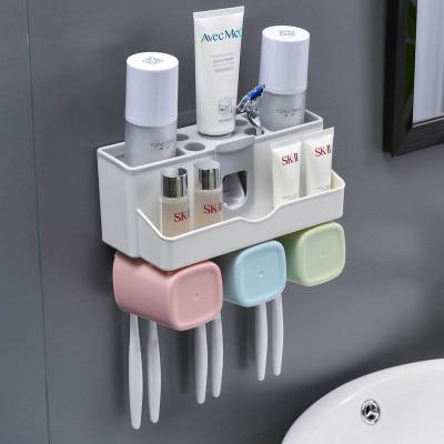 China Super Sustainable Sticky Wall Mounted Plastic Automatic Toothpaste Dispenser Toothbrush Holder With 3 Cups for sale