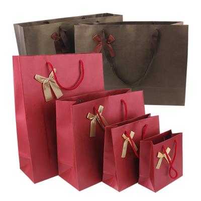 China Custom logo kraft paper bag thickening clothing shopping special paper bag recyclable with ribbon handle for sale