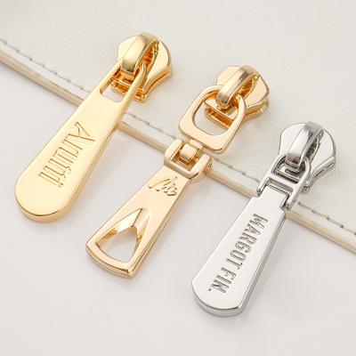 China Custom Zipper Pulls Silver Engraved Logo Metal Zipper Puller for High Grade Clothing for sale