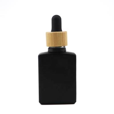 China Bamboo collar+rubber+glass pipette lead industry 30ml 30 ml 1oz rectangle black cosmetic rectangular matte dropper square frosted glass bottle with bamboo lid for sale