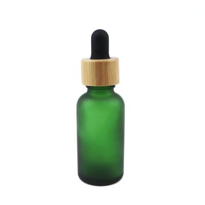 China Fancy Matte Green Fashion Bamboo Rubber Attractive Design Cap+Glass Pipette+Silicone Collar Bottles Custom Made Or Standard Color Perfume 30ml Essential Oil 1oz Dropper Glass Bottle for sale