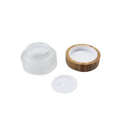 China Eco-Friendly Bamboo Cap With Filling Wholesale Price 30g Empty Body Butter Mini Scrub Clear Matte White Cosmetic Round Glass Jar With Wooden Cap Spoon For Cream for sale