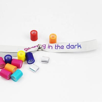 China Glowing promotional glow in the dark event ribbon wristband with a resting loop for sale