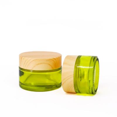 China High Grade Cosmetic Light Green Shading Glass Cosmetic Cream Jar With Wood Grain Caps for sale