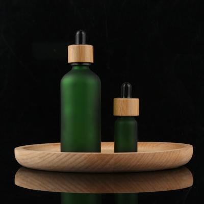 China 0.5oz 15ml Matte Green Glass Cosmetic Empty Bottle With Bamboo Dropper For Massage Vape Oil for sale