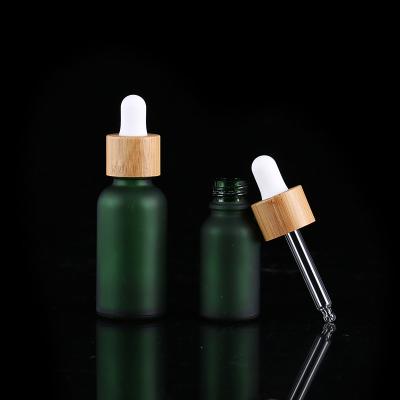 China Eco-friendly 1oz 30ml Matte Green Cosmetic Essential oil dropper bamboo glass bottle for massage oil for sale