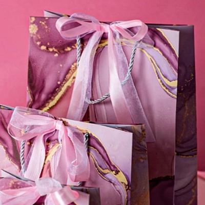 China Recyclable Printing Custom Patterns Luxury Paper Bag Gift Packaging With Ribbon And Rope Handle for sale