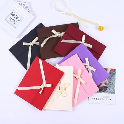 China Custom Fancy Colored Paper T-shirt Mini Gift Wrap Wrap Gift Voucher Wrapping Bag Packaging Box Bowknot With Ribbon Closure for sale