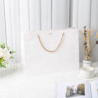 China Yiwu Disaster Shopping Handmade Wholesale Flat Bottom White Print Embossed Shopping Kraft Paper Bag With Ribbon for sale