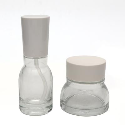 China Unique Shape 30g 50g 40ml 100ml 120ml Personal Care Product Glass Bottle Transparent Clear Packaging Set For Cosmetic for sale