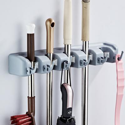 China Durable Plastic 4 Slot 5 Hook Household Goods Stick Broom Tools And Organizer Wall Mounted Hnager Broom Holder for sale