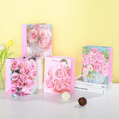 China Recycled Materials luxury flat kraft paper bags handles wholesale with logo square bottom jewelry flowers pink roses mother lady Spanish for sale