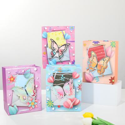 China Recycled Materials luxury paper bag packaging types of paper clothing wholesale customized luxury Cartoon dinosaur boy Easter butterfly for sale