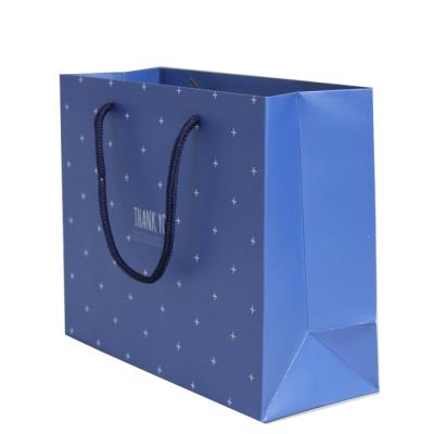 China Custom Recyclable Recycled Dark Blue Shopping Kraft Paper Packaging Bag With Gold Foil Logo And Twisted Handle for sale