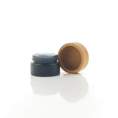 China Whole Sales Eye Cream Bamboo Cosmetic Cream Jar 5g Mini Round Black Frosted Glass Jar With Bamboo Lid for sale