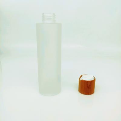 China Wholesale 100ml frostrd glass cosmetic bottle with bamboo press lid for sale