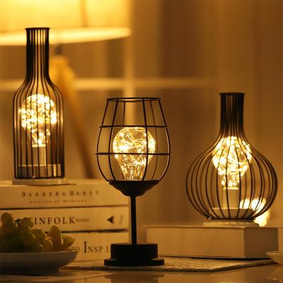 China New-designed retro wrought iron art lamp table Buy Online Hollow Winebottle LED Table Lamp for bedroom decoration for sale