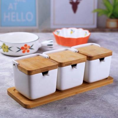 China Viable Wholesale Kitchen Food Porcelain Storage Bottles And Jar Set With Seal Lid Wood Tray Salt Shaker Ceramic Spice Bamboo Jar for sale